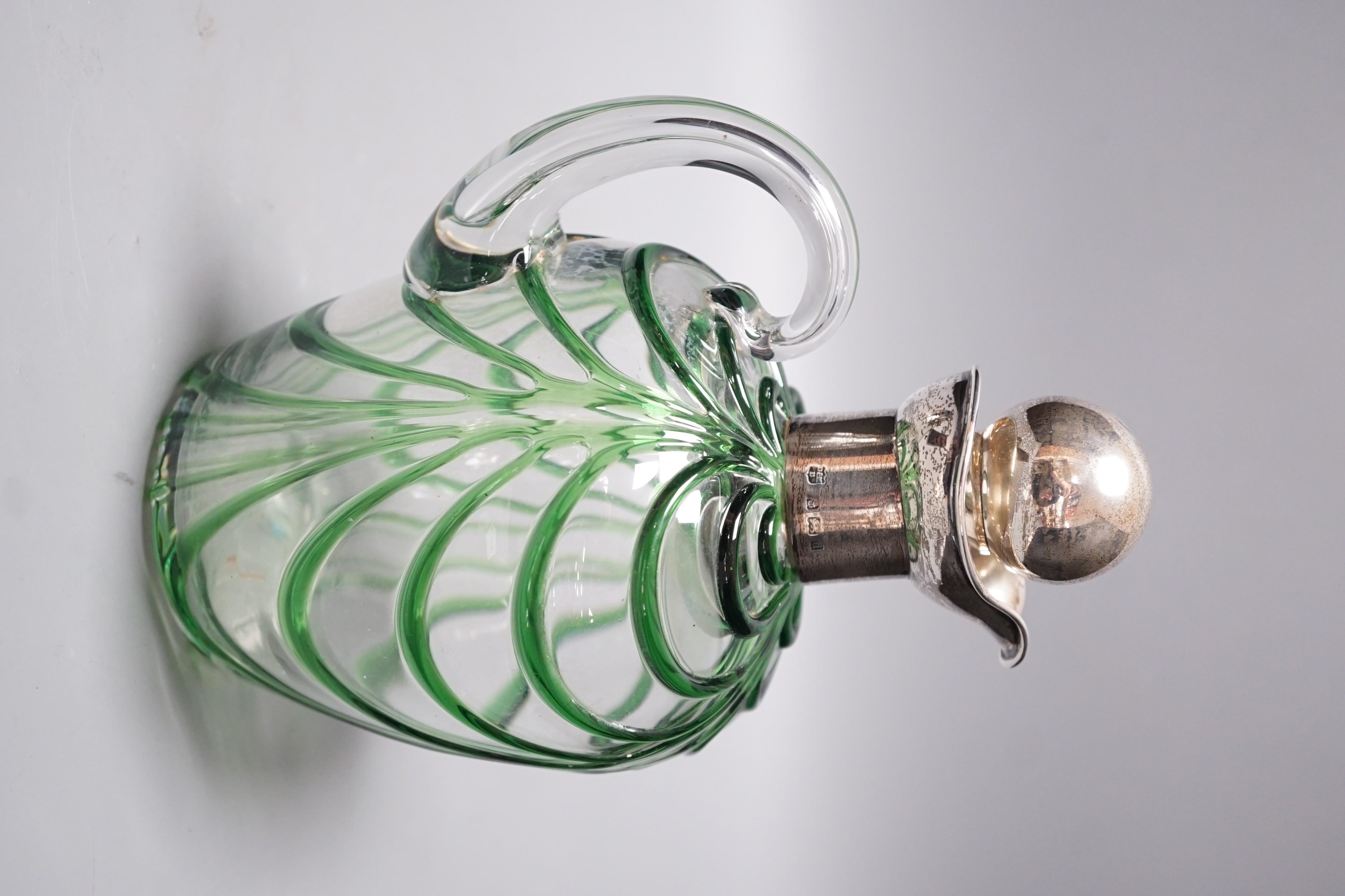 A late Victorian Art Nouveau silver mounted glass claret jug and stopper, D & M Davis, Birmingham, 1900, the glass with ribbed green swags, height 20.7cm.
